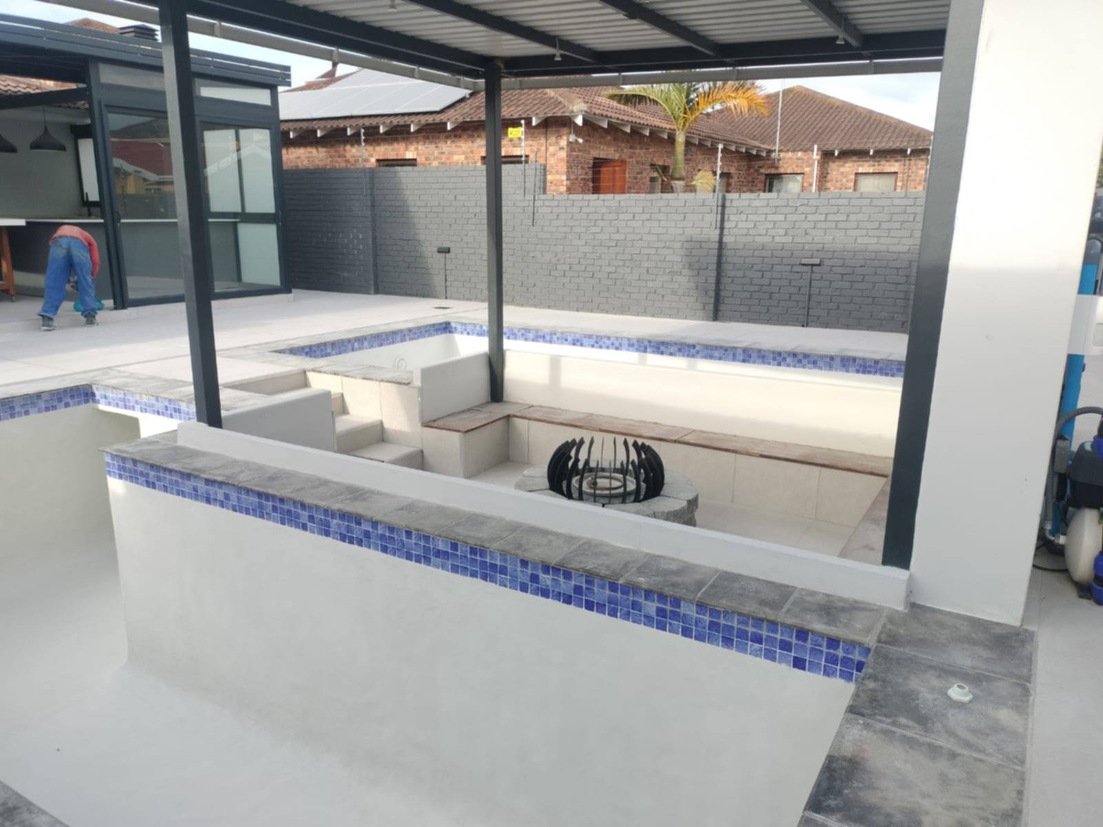 Custom pool construction in Gqeberha with sunken lounge and fire pit alongside completed swimming pool